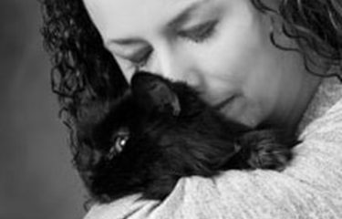 Owner (woman) kissing pet cat